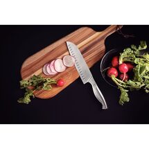 Αναβαθμίστε την εμπειρία προετοιμασίας των γευμάτων σας με το μαχαίρι Santoku Tramontina Sublime 7.5 ιντσών. Σχεδιασμένο με βάση το παραδοσιακό ιαπωνικό στυλ, είναι το απόλυτο εργαλείο για να κόβετε σε φέτες, να τεμαχίζετε σε κύβους και να ψιλοκόβετε λαχανικά, κρέατα ή ψάρια με απίστευτη ευκολία. Κατασκευασμένο εξολοκλήρου από ανοξείδωτο ατσάλι, διακρίνεται για τις ειδικές εγκοπές στη λεπίδα του, οι οποίες αποτρέπουν τις τροφές από το να κολλάνε κατά τη διάρκεια της κοπής, προσφέροντάς σας μια απόλυτα ομαλή και γρήγορη ροή εργασίας.

Γιατί ξεχωρίζει:

Premium Μονοκόμματο Design: Λεπίδα και χειρολαβή αποτελούν ένα ενιαίο, στιβαρό σώμα από ανοξείδωτο ατσάλι, διατηρώντας τα αρχικά χαρακτηριστικά, τη λάμψη και την αισθητική του αναλλοίωτα στο χρόνο.

Υψηλή Ανθεκτικότητα & Σκληρότητα: Η ανοξείδωτη λεπίδα του έχει υποστεί θερμική επεξεργασία, γεγονός που εγγυάται εξαιρετικά αποτελεσματική κοπή και μεγάλη διάρκεια ζωής.

Μέγιστη Υγιεινή & Ασφάλεια: Η ενιαία μεταλλική κατασκευή εξαλείφει τις σχισμές και τις ενώσεις, εμποδίζοντας τη συσσώρευση υπολειμμάτων τροφών. Είναι 100% κατάλληλο για το πλυντήριο πιάτων.